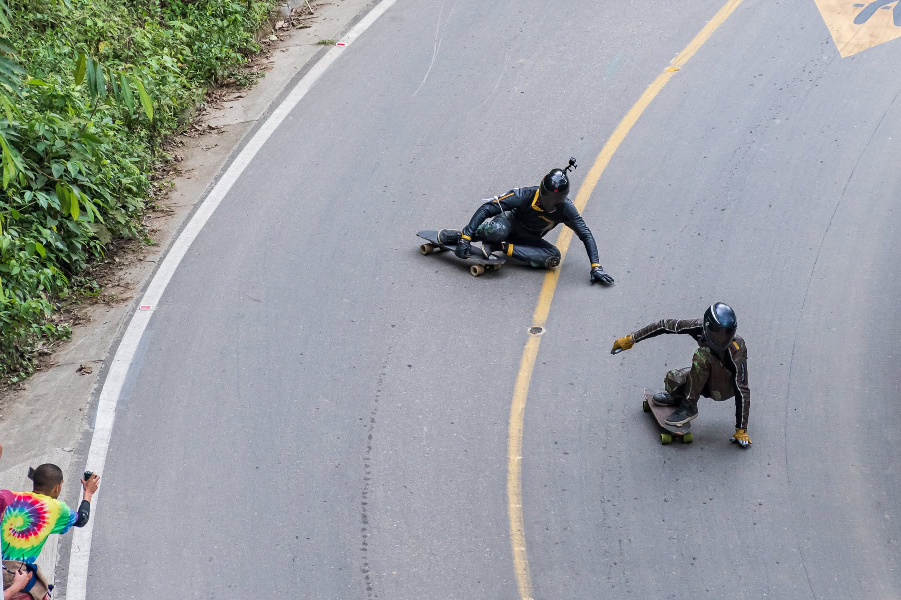 Dos corredores de downhill skate en plena bajada